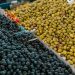 A vibrant selection of black and green olives at an outdoor market stall.